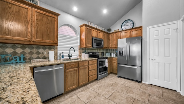 kitchen with decorative backsplash, stainless steel appliances, sink, light stone countertops, and high vaulted ceiling