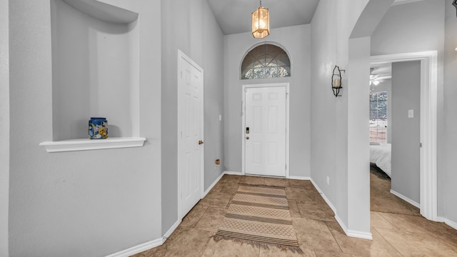 foyer with ceiling fan and light tile patterned flooring