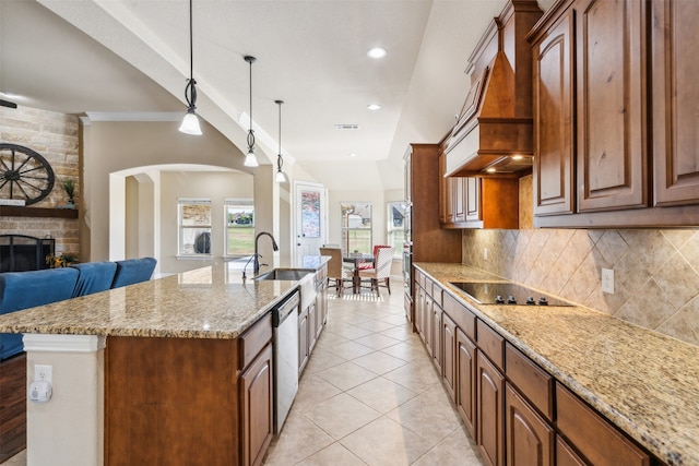 kitchen featuring hanging light fixtures, a kitchen island with sink, dishwasher, a fireplace, and black electric stovetop