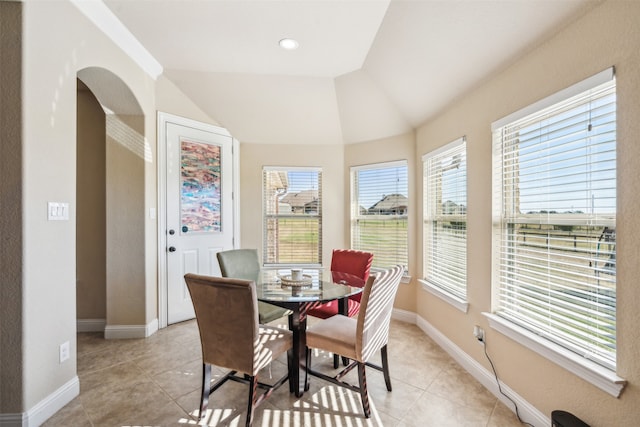 tiled dining space with vaulted ceiling