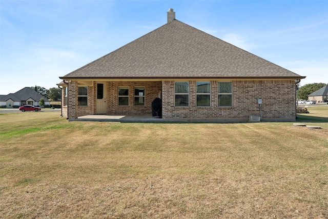 rear view of house with a yard and a patio