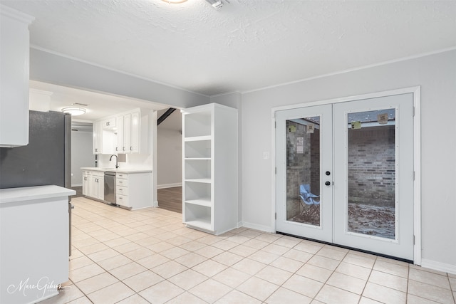 kitchen featuring french doors, white cabinets, black refrigerator, stainless steel dishwasher, and light tile patterned floors