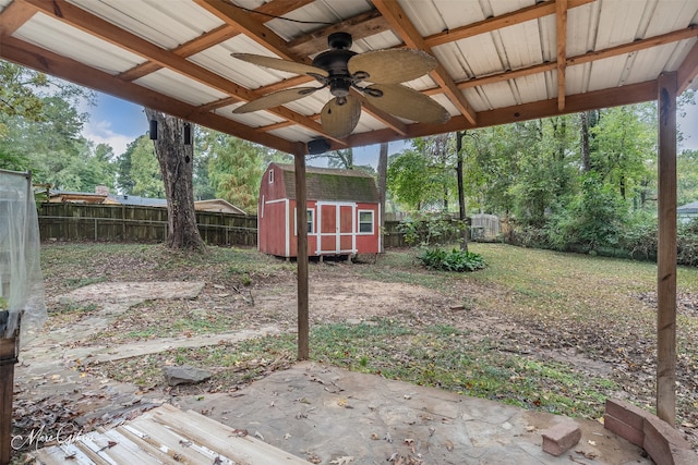 view of yard with ceiling fan and a storage shed