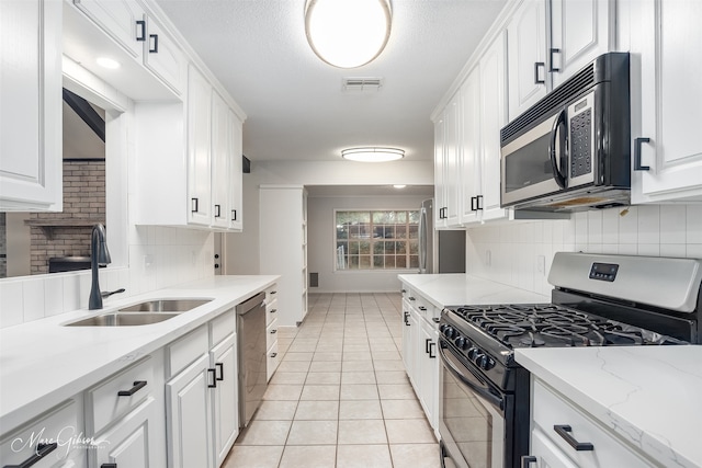 kitchen featuring white cabinets, appliances with stainless steel finishes, backsplash, and sink