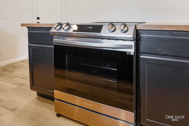 details with light hardwood / wood-style floors, butcher block counters, and stainless steel range with electric cooktop