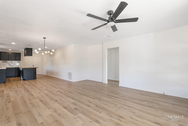 unfurnished living room with light hardwood / wood-style floors and ceiling fan with notable chandelier