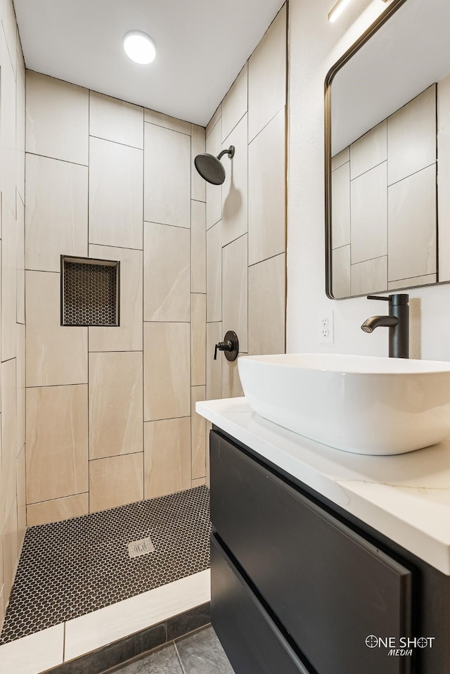 bathroom featuring vanity, tiled shower, and tile patterned flooring