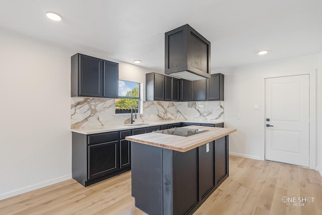 kitchen featuring backsplash, wood counters, light hardwood / wood-style flooring, black electric stovetop, and sink