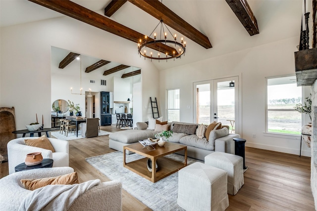 living room featuring a healthy amount of sunlight, french doors, a chandelier, and hardwood / wood-style flooring