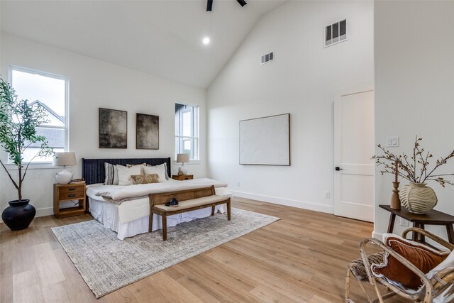 bedroom with light hardwood / wood-style floors and high vaulted ceiling