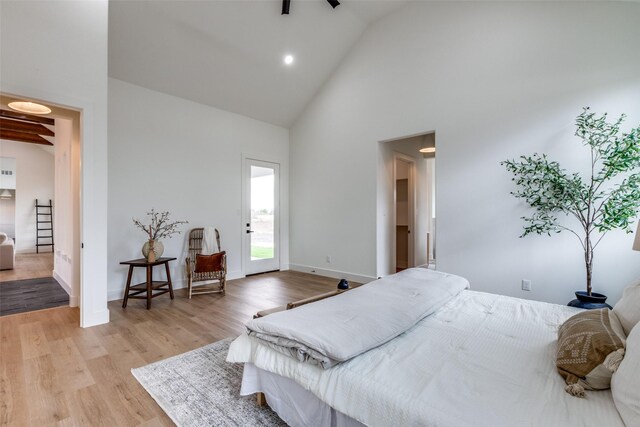 bedroom featuring light wood-type flooring, access to exterior, and high vaulted ceiling