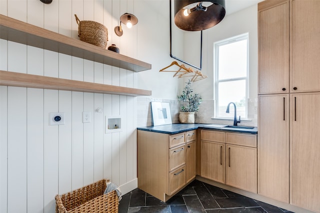 laundry area featuring sink, wooden walls, washer hookup, electric dryer hookup, and cabinets