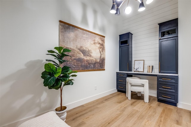 office space featuring built in desk and light wood-type flooring