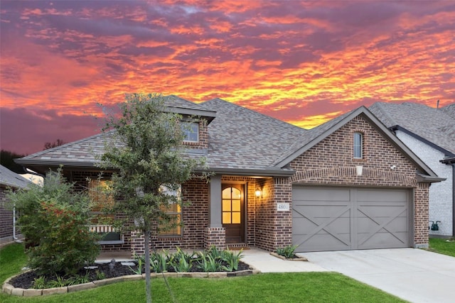 view of front of home with a yard and a garage