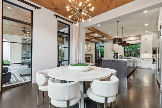 dining space with sink, beam ceiling, dark hardwood / wood-style flooring, and ceiling fan with notable chandelier