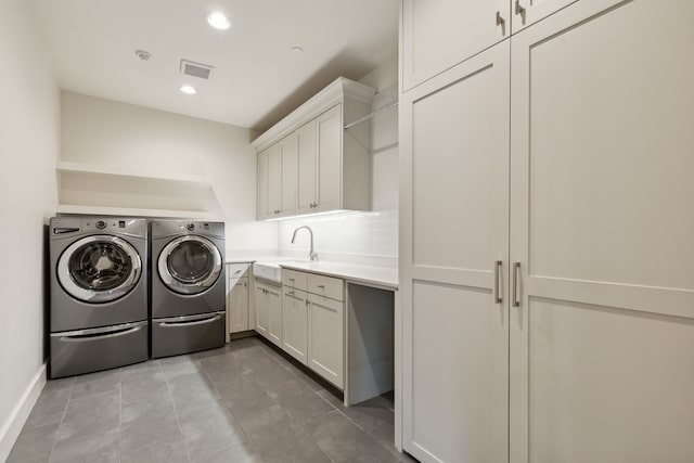 washroom featuring sink, light tile patterned floors, cabinets, and separate washer and dryer