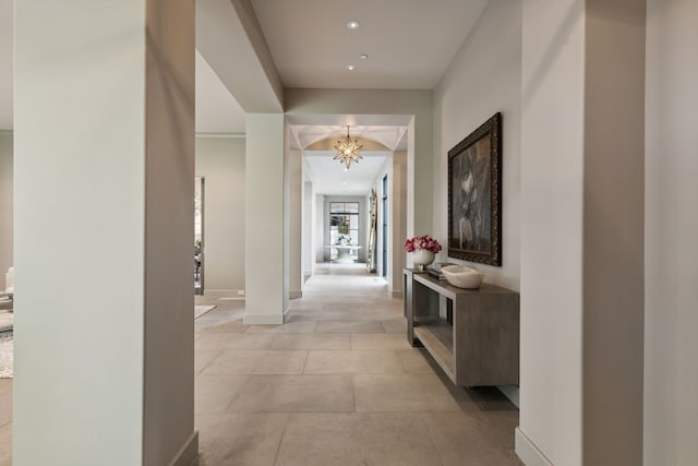 corridor featuring a notable chandelier and light tile patterned floors