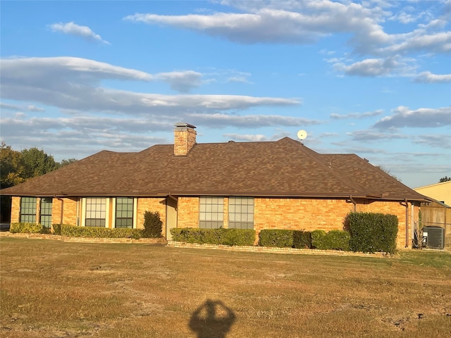 single story home featuring a front lawn and central AC unit