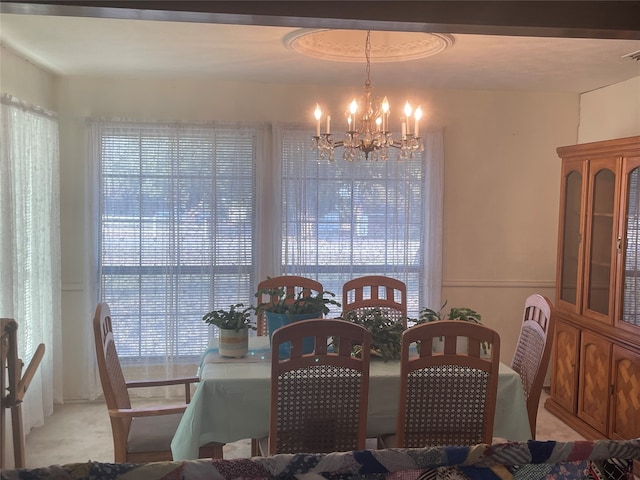 dining space with a water view and a notable chandelier