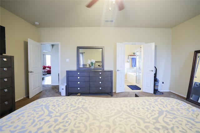 carpeted bedroom with ensuite bathroom and ceiling fan