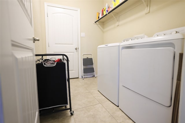 laundry room featuring washer and clothes dryer and light tile patterned floors