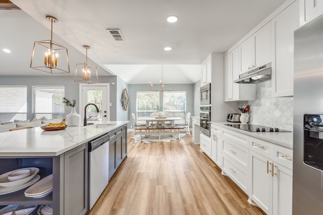 kitchen featuring white cabinets, sink, stainless steel appliances, and pendant lighting