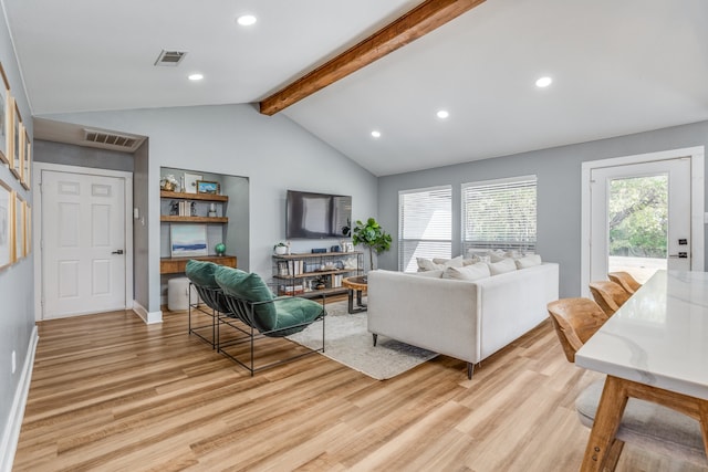 living room featuring light hardwood / wood-style floors, lofted ceiling with beams, and plenty of natural light