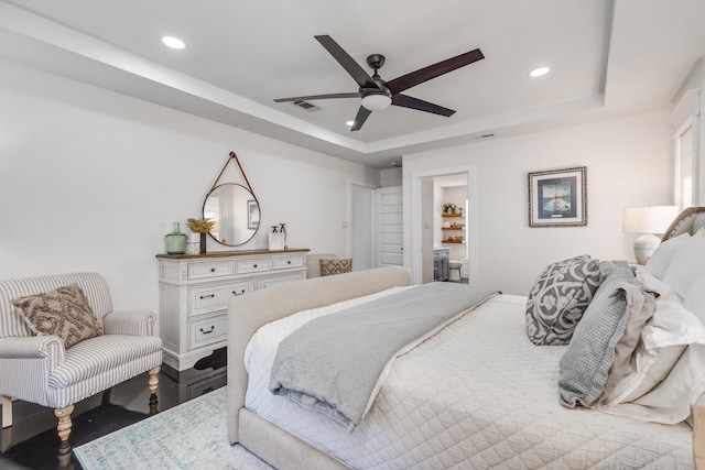 bedroom featuring ceiling fan, a tray ceiling, and hardwood / wood-style floors