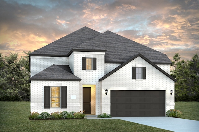 view of front of home with a yard and a garage