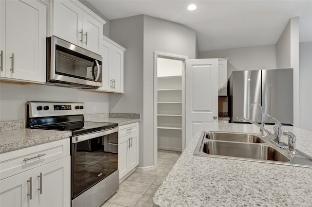 kitchen with appliances with stainless steel finishes, white cabinetry, and sink