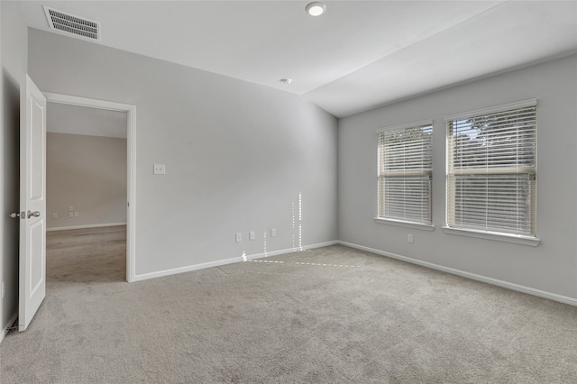 unfurnished room with vaulted ceiling and light colored carpet