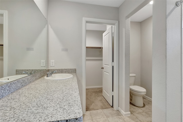 bathroom featuring toilet, vanity, and tile patterned floors