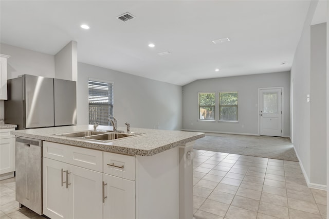 kitchen featuring sink, stainless steel appliances, white cabinets, light colored carpet, and a kitchen island with sink