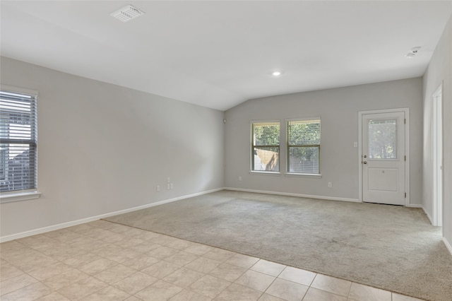 carpeted spare room featuring vaulted ceiling