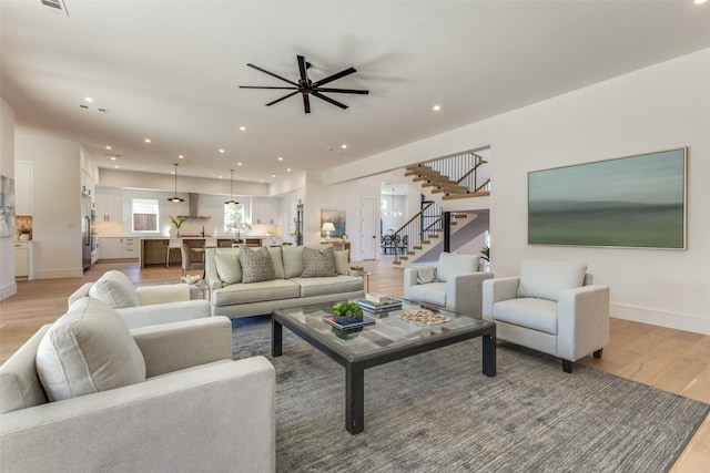 living room with ceiling fan and light wood-type flooring