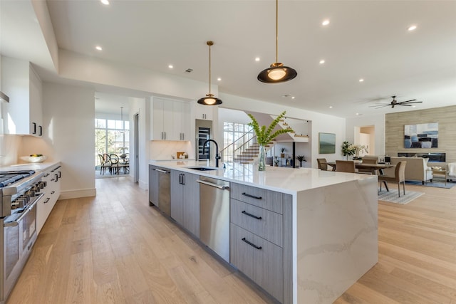 kitchen featuring stainless steel dishwasher, gray cabinetry, ceiling fan, decorative light fixtures, and white cabinetry