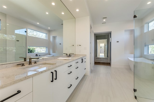 bathroom with vanity and shower with separate bathtub