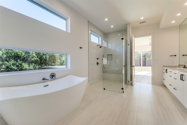 bathroom with tile patterned flooring, shower with separate bathtub, and vanity