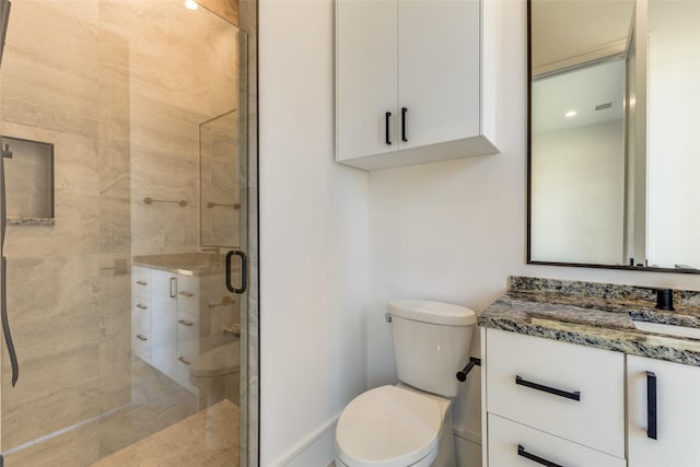 bathroom featuring vanity, toilet, and a shower with door