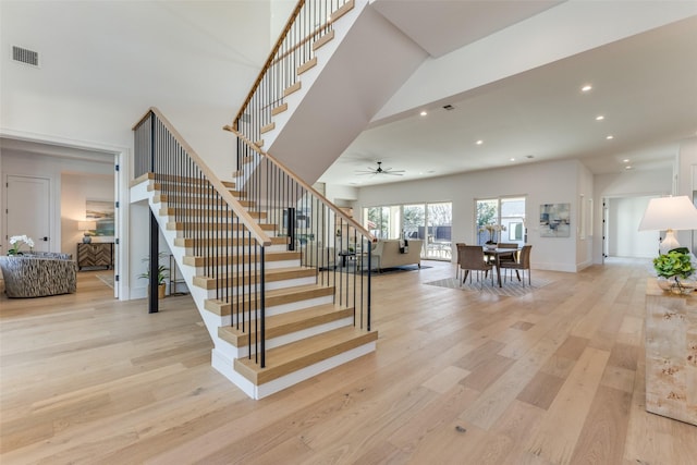 stairs featuring hardwood / wood-style flooring and ceiling fan