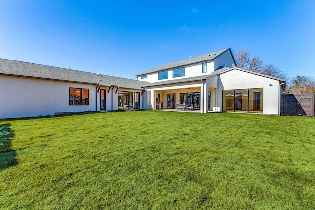 rear view of house with a patio area and a lawn