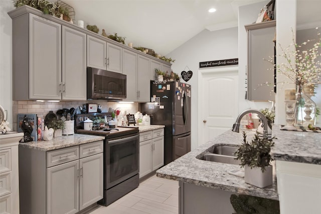 3016 Loy Lake Rd, Denison, TX 75020 - kitchen featuring stainless steel microwave, electric range oven, a sink, freestanding refrigerator, and tasteful backsplash