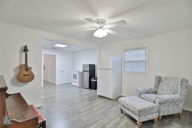 sitting room with ceiling fan and light wood-type flooring