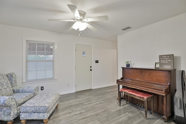 living area with light hardwood / wood-style floors and ceiling fan