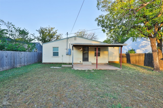 rear view of property featuring a patio and a lawn