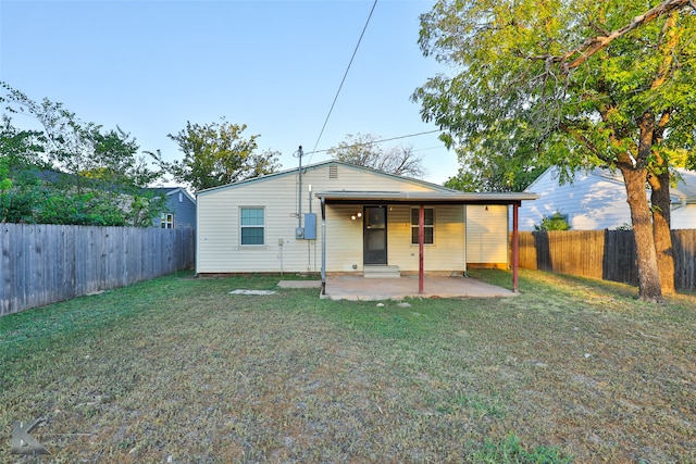 rear view of house with a yard and a patio area