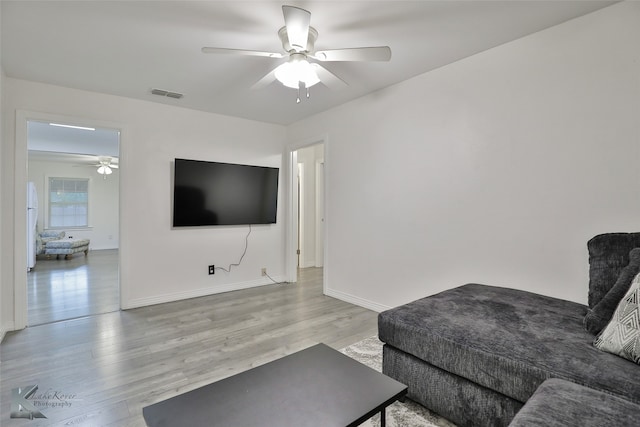 living room with wood-type flooring and ceiling fan