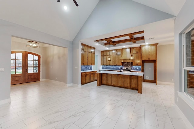 kitchen with a center island with sink, decorative backsplash, high vaulted ceiling, pendant lighting, and french doors