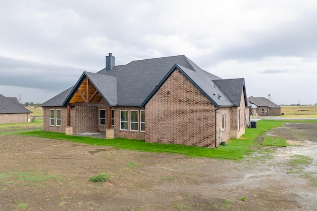 back of property with central AC and a patio area