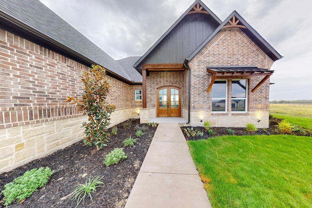 view of front of home with a front yard and french doors